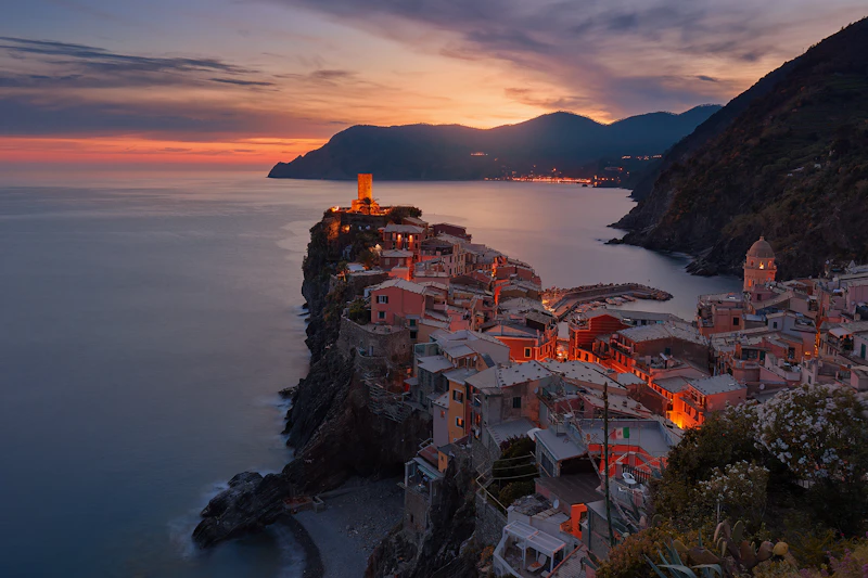 Village coloré perché sur un rocher au bord de la mer, au crépuscule